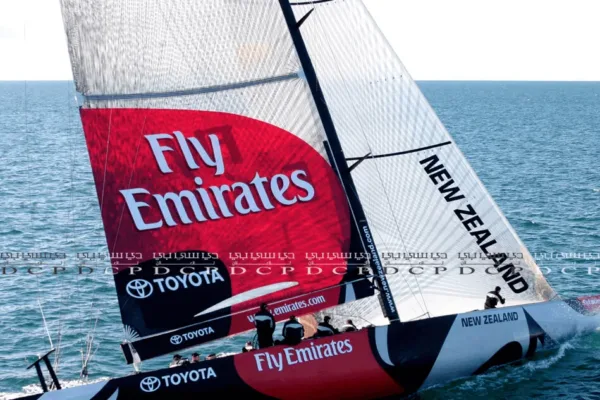Boat Sail with Custom Branding Custom-branded sail with a vibrant logo displayed on a sailboat, cutting through the water during a sunny day